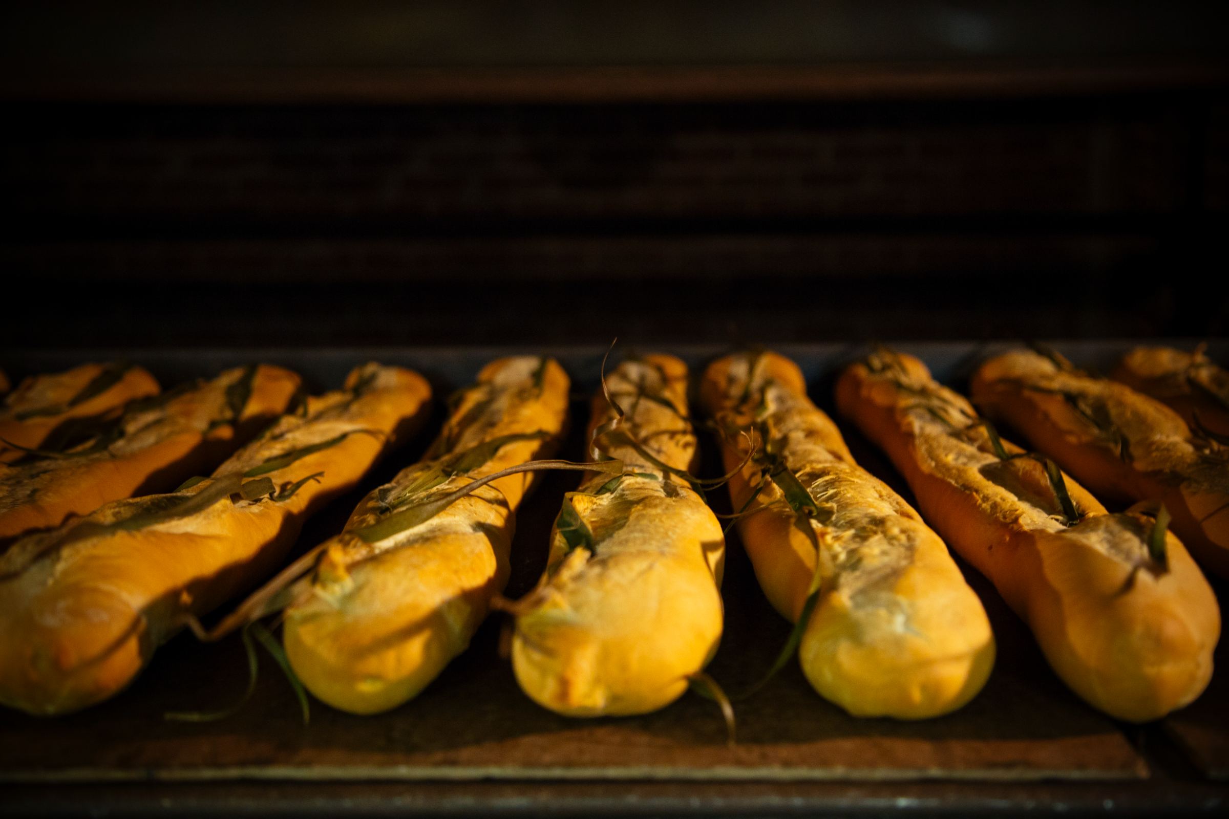 A row of La Segunda Cuban bread loaves with the signature palmetto-leaf split, baked in Ybor City, Tampa.